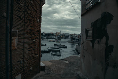 Buildings by sea against sky