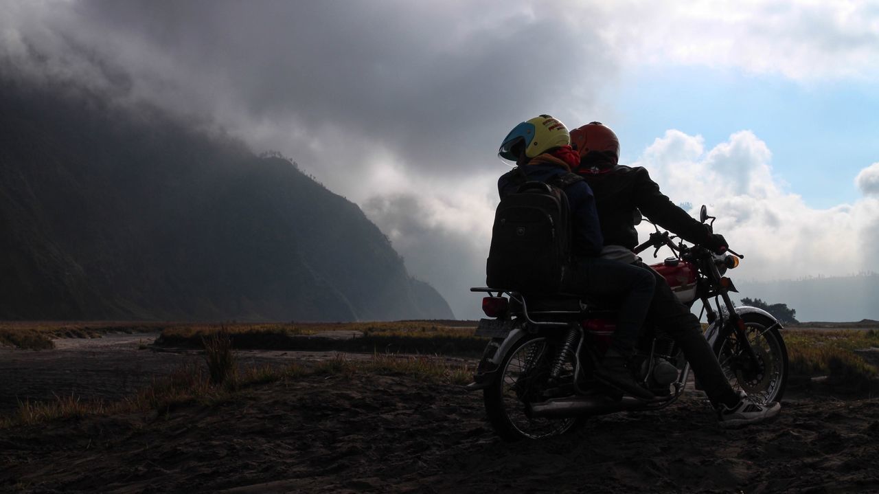 sky, transportation, lifestyles, land vehicle, men, bicycle, mode of transport, cloud - sky, leisure activity, full length, riding, rear view, landscape, casual clothing, cloud, cloudy, backpack