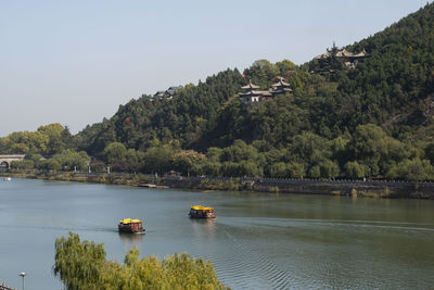 Scenic view of river by trees against sky