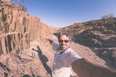 Man by pipe organ at damaraland on sunny day