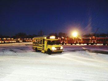 Cars on snow covered landscape at night