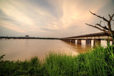 Bridge over river against sky during sunset