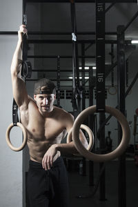 Midsection of shirtless man holding camera