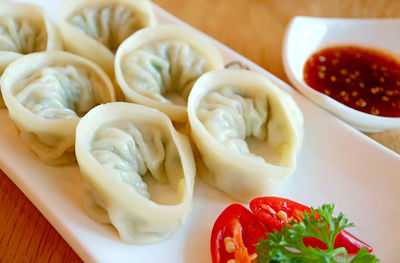 Closeup a plate of steamed mandu or korean dumplings served on wooden table