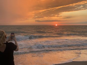 Scenic view of sea against sunset sky