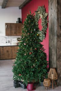 Christmas tree with toys and gifts under it in the dining room of a country house