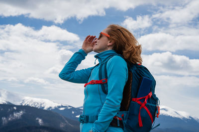 Rear view of friends standing against mountain