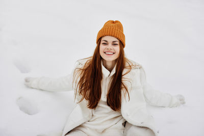 Portrait of young woman standing against white background