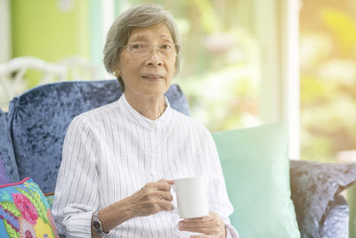 Portrait of senior woman drinking coffee at home