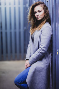 Portrait of young woman leaning outdoors