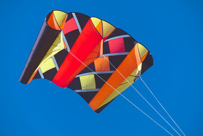 Low angle view of flags against clear blue sky