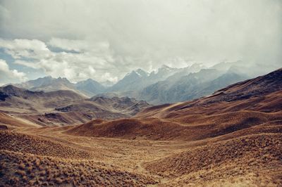 Scenic view of mountains against cloudy sky