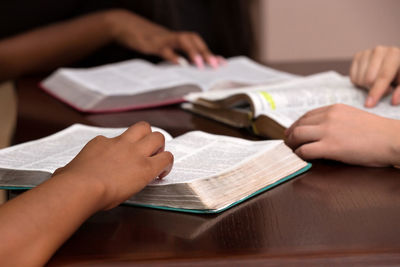 Hands of students holding books at desk