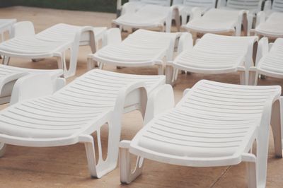 Empty chairs arranged at poolside