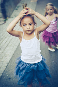 Portrait of girls dancing on road