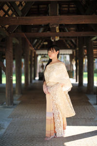 Full length of woman standing under wooden structure