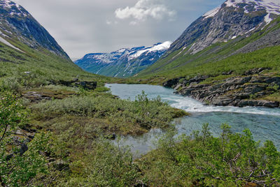 Scenic view of river amidst mountains against sky