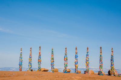 Multi colored umbrellas on beach against blue sky