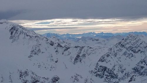 Scenic view of mountains against cloudy sky