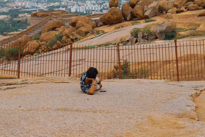 Man sitting on rock against mountains