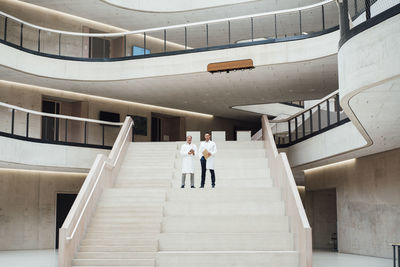 Doctors standing on staircase in hospital lobby