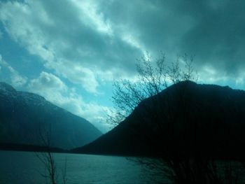 Scenic view of lake by mountains against sky