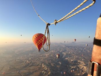 Hot air balloons flying over landscape against sky