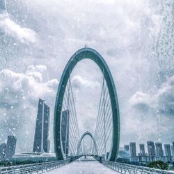 View of bridge and cityscape against sky