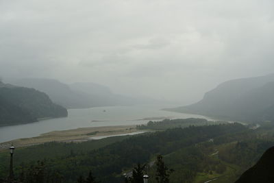 Scenic view of sea and mountains against sky