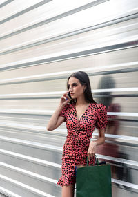 Beautiful young woman looking at camera while standing outdoors