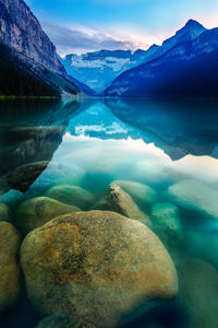 Scenic view of lake by mountains against sky