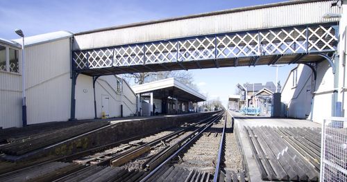 Railroad tracks amidst buildings against sky