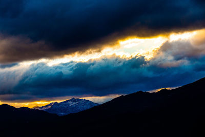 Scenic view of dramatic sky over silhouette landscape