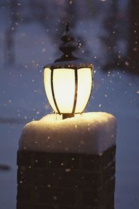 Close-up of wet illuminated lamp in rainy season