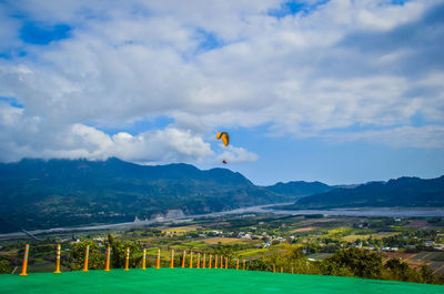 Hot air balloons flying over field against sky