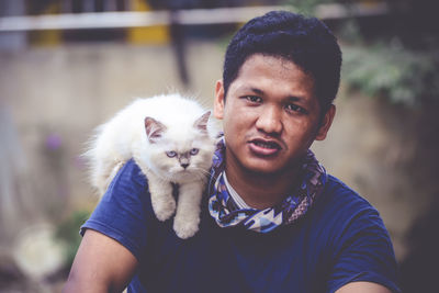 Portrait of young woman holding cat