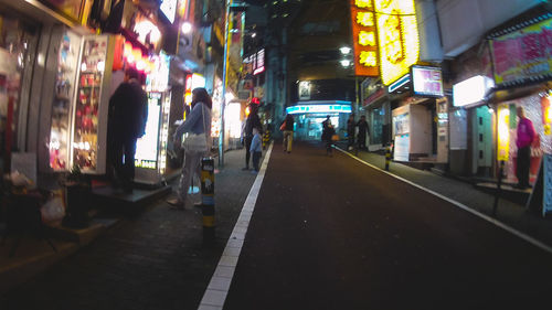 People on illuminated street at night