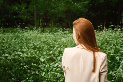 Rear view of woman standing against plants