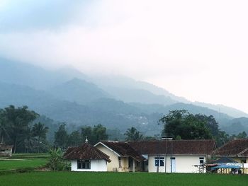 Houses on mountain against sky