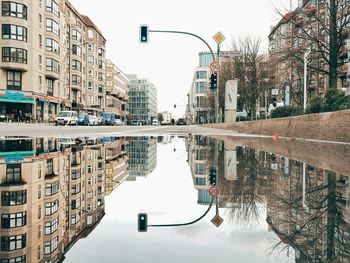 Signal with buildings reflection in puddle on street