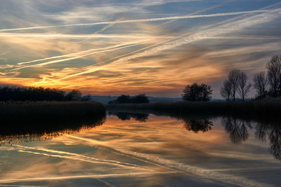 Scenic view of lake against sky at sunset