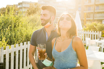 Portrait of young man drinking glasses outdoors