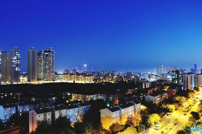 High angle view of illuminated buildings against sky at night