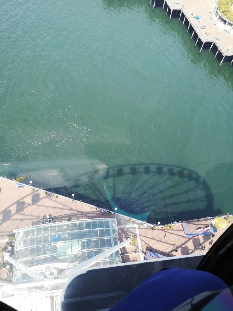 HIGH ANGLE VIEW OF SWIMMING POOL AGAINST SEA