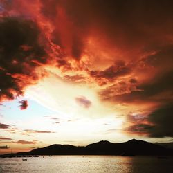 Scenic view of sea against cloudy sky at sunset