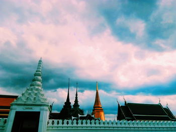 Low angle view of buildings against cloudy sky