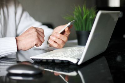 Midsection of man using laptop on table