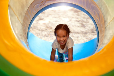 Full length of smiling girl playing in playground