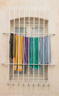 Close-up of multi colored clothes over behind bars