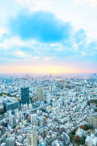 High angle view of modern buildings against sky during sunset